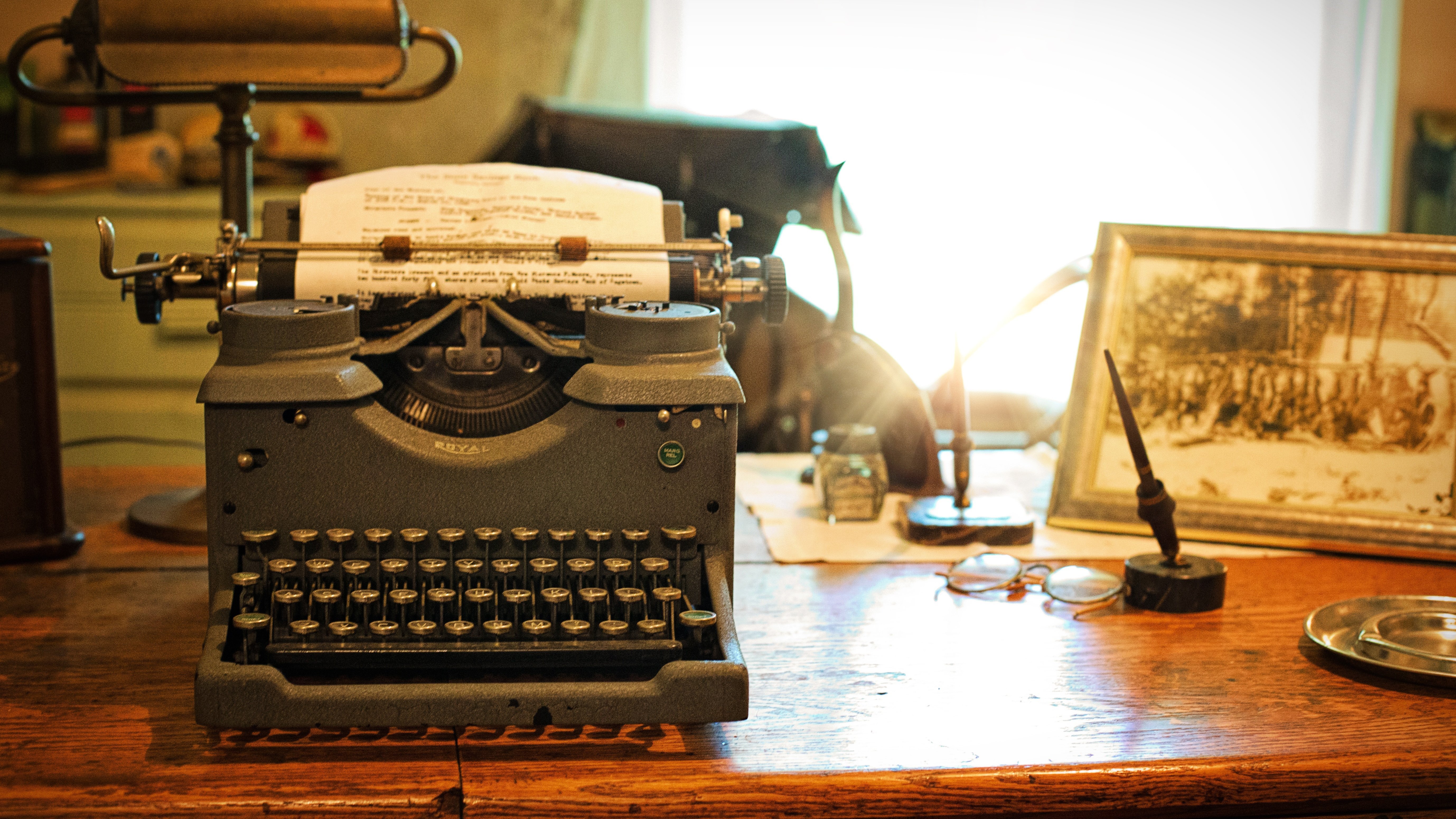 Vintage Typewriter at Hirschen Wohlfühlhotel A vintage typewriter on a wooden desk with decorative items creating a nostalgic vibe