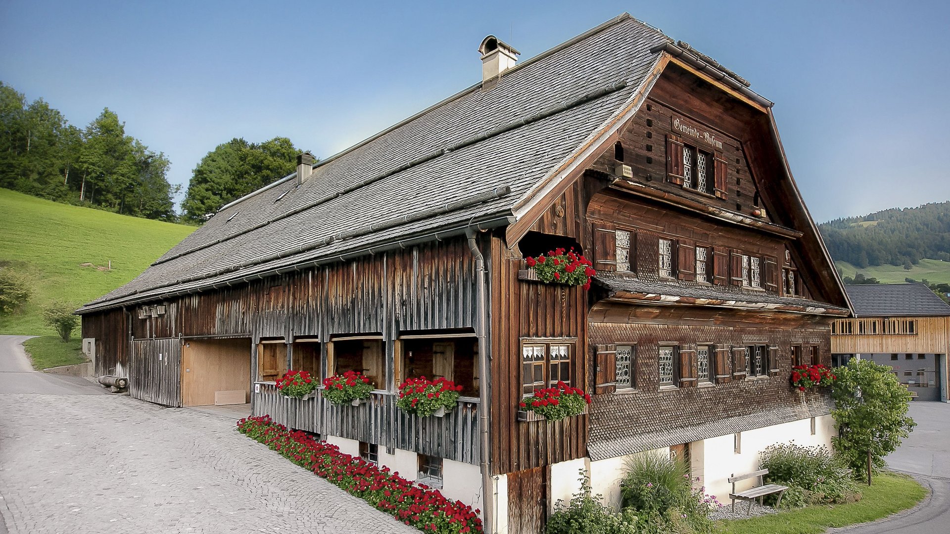 Charming Traditional Hotel in Scenic Landscape Traditional wooden hotel exterior featuring flower boxes surrounded by green landscape